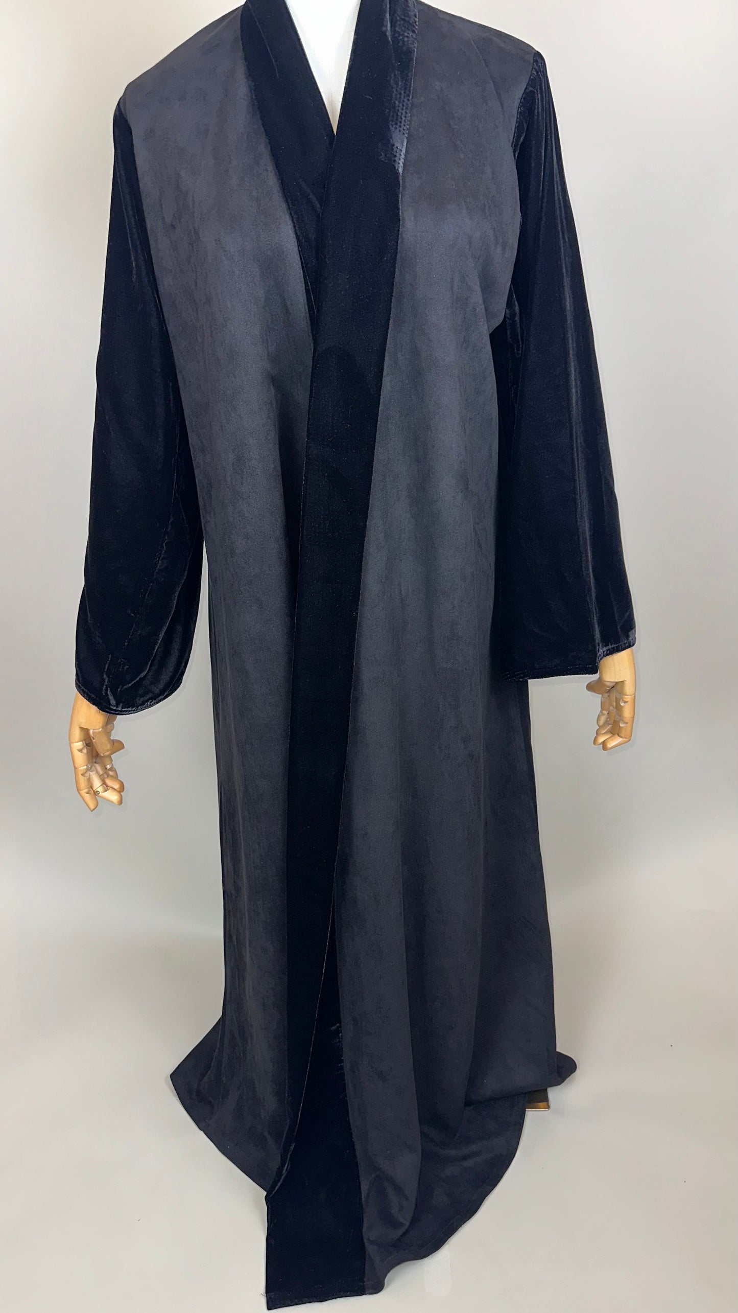 Long black velvet robe with wide sleeves on mannequin against neutral background