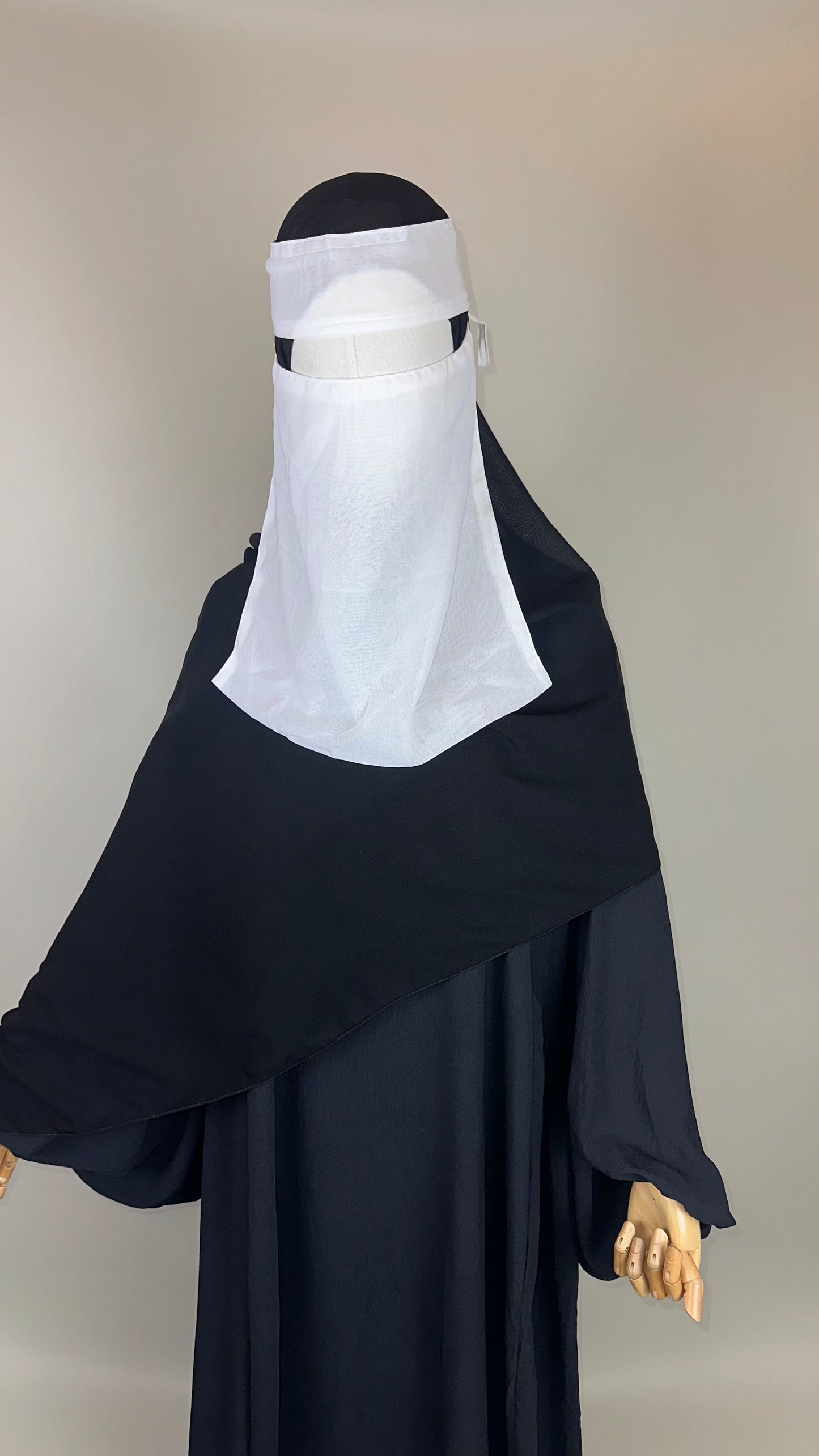 Mannequin wearing black abaya and white niqab face veil, modest Islamic clothing