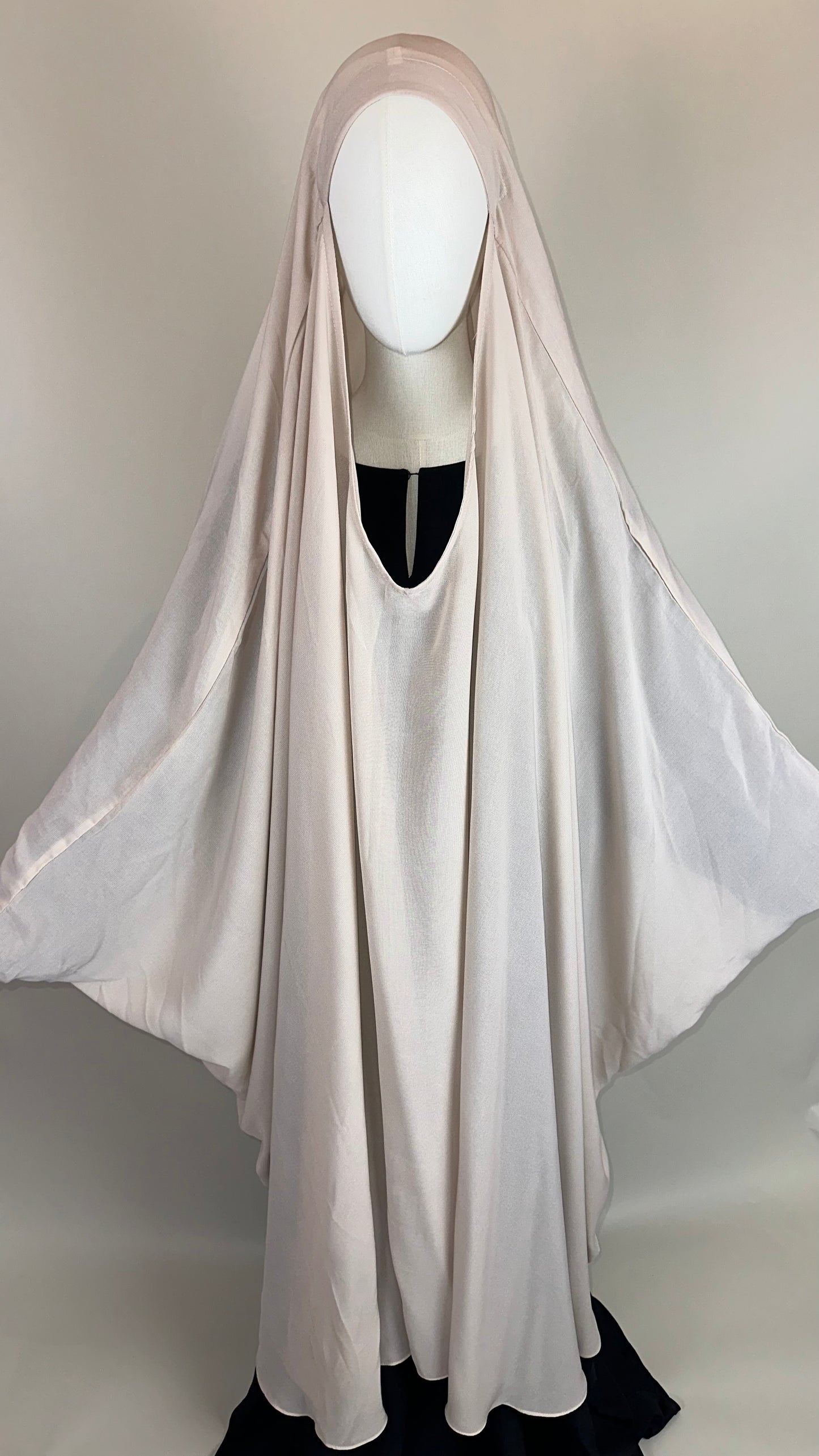 Ivory khimar abaya on mannequin, modest Islamic clothing, draped in soft fabric