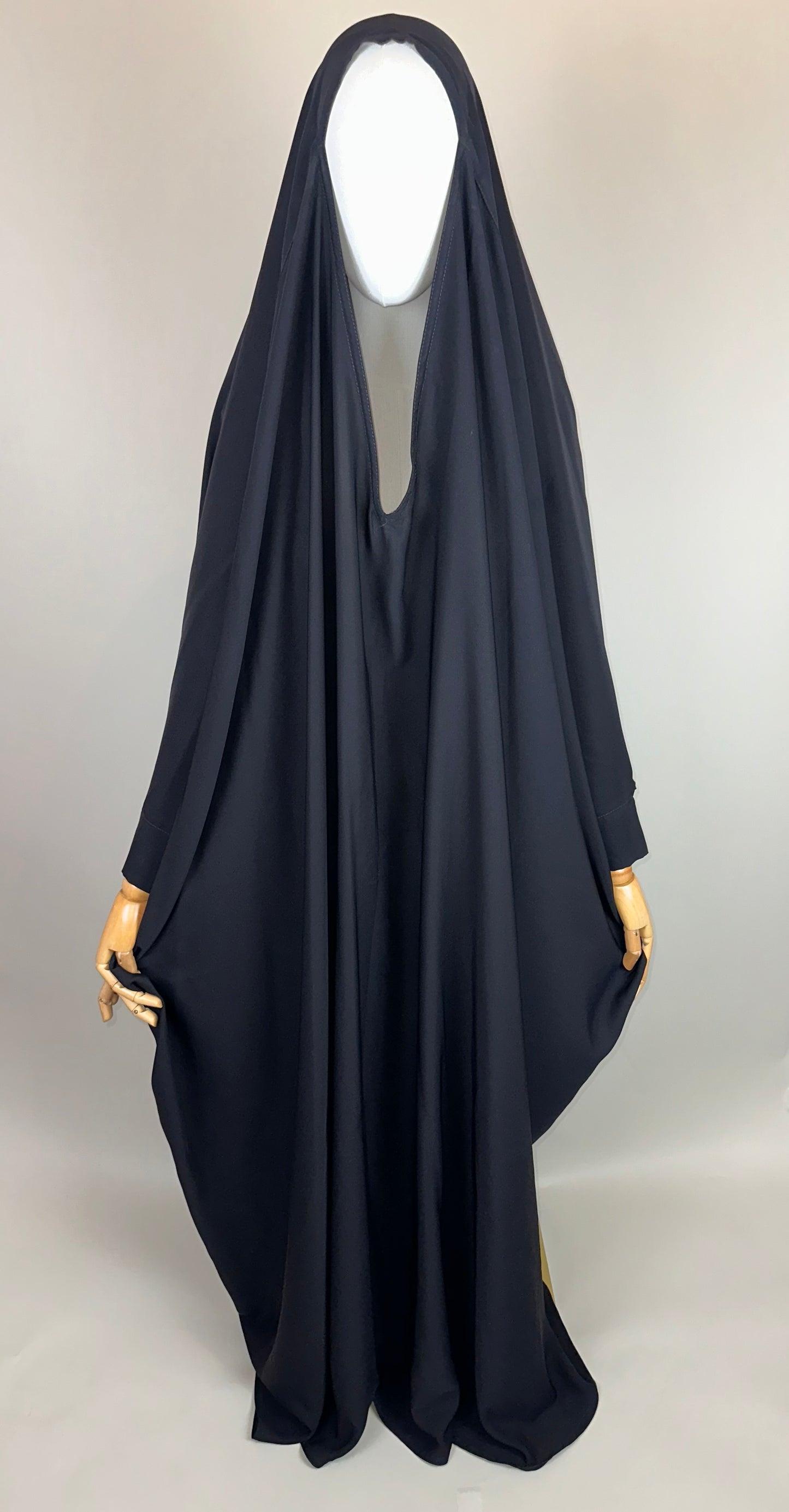 Black overhead abaya on mannequin, modest Islamic clothing, neutral background