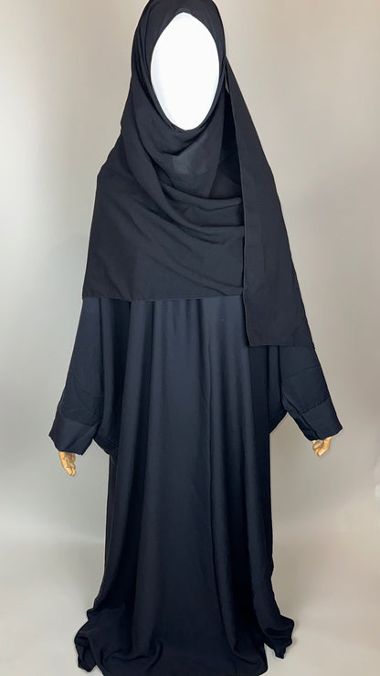 Black abaya and khimar set displayed on mannequin in studio lighting