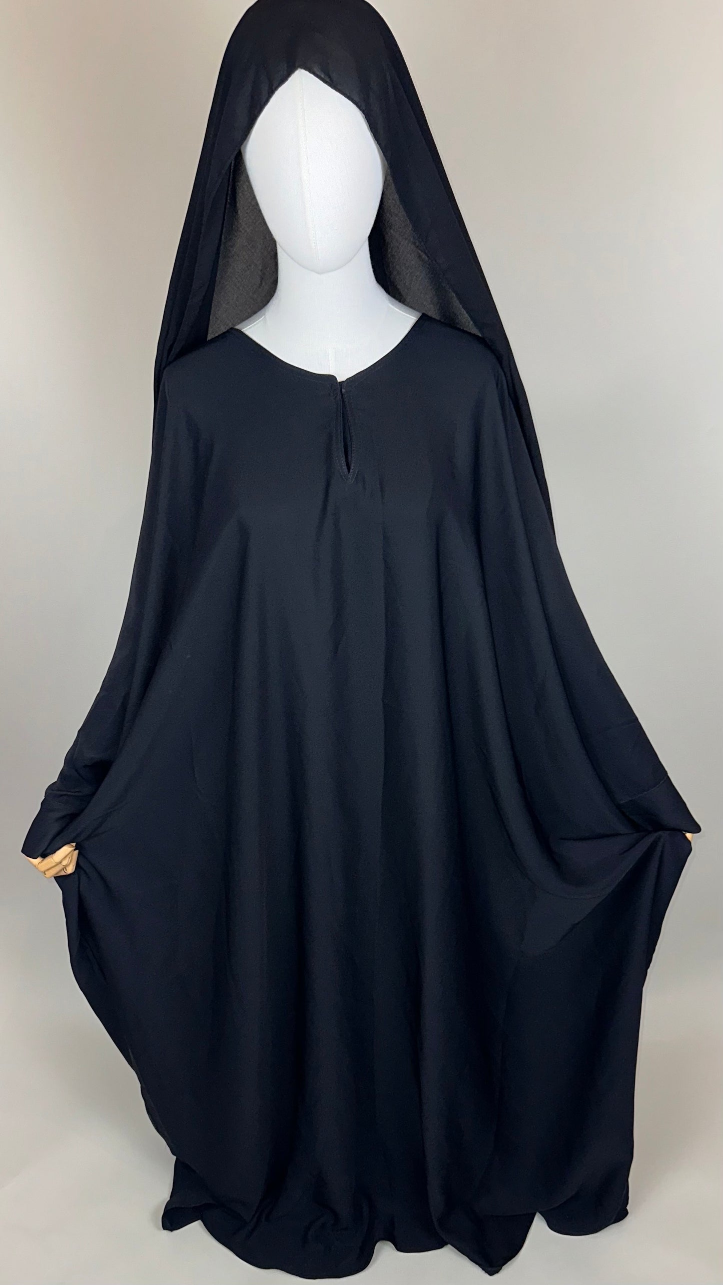 Black hooded cloak displayed on mannequin against plain background