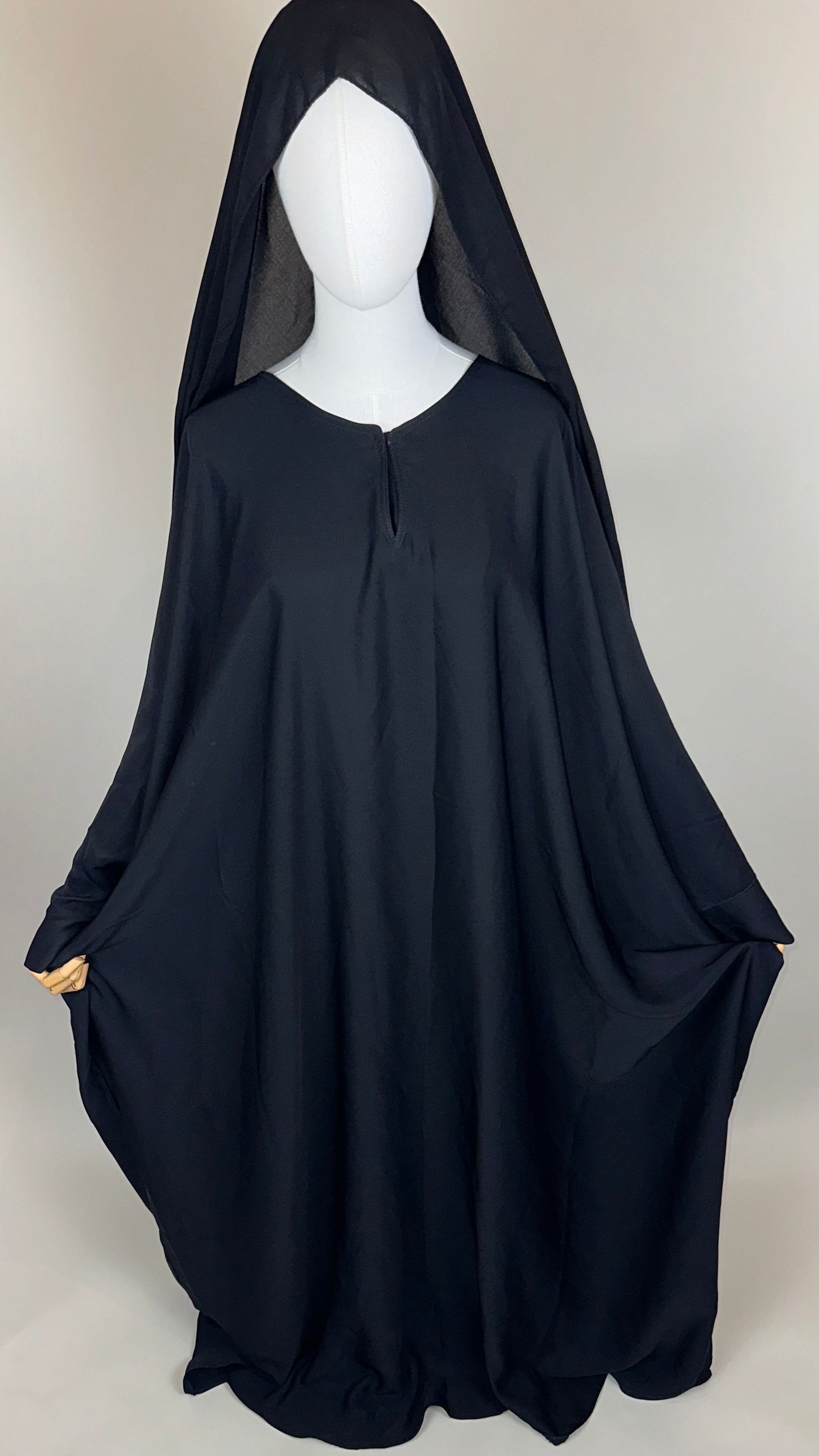Black hooded cloak displayed on mannequin against plain background