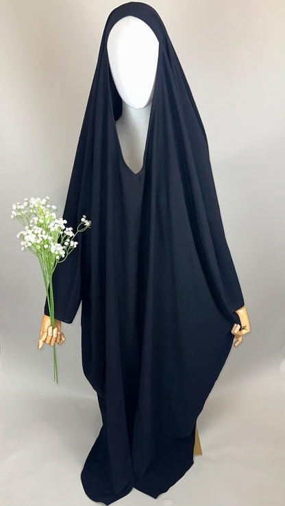 Mannequin in black abaya holding white flowers, plain background