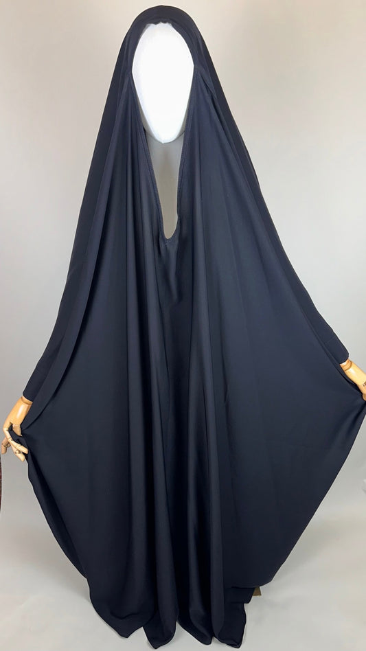 Plain black Islamic chador draped on mannequin in studio setting